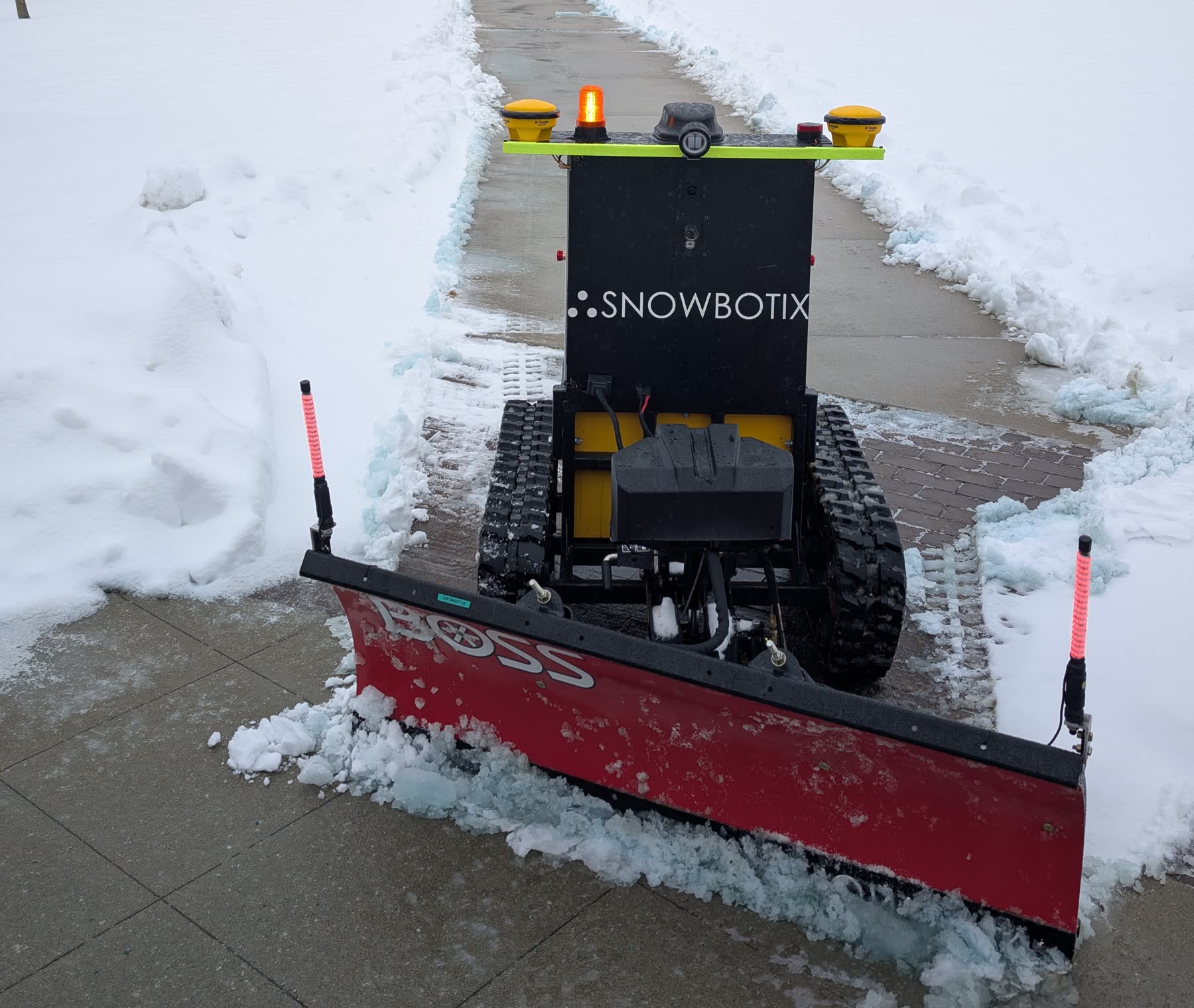 Snowbotix autonomous snow robot clearing a pathway in winter conditions