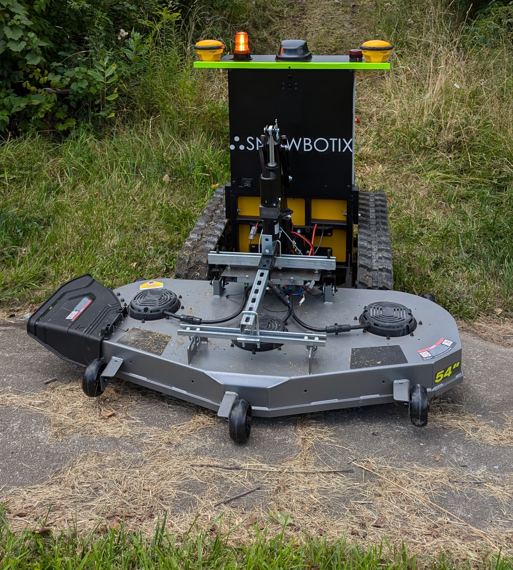 Snowbotix robot maintaining a landscaped area with its mowing deck attached